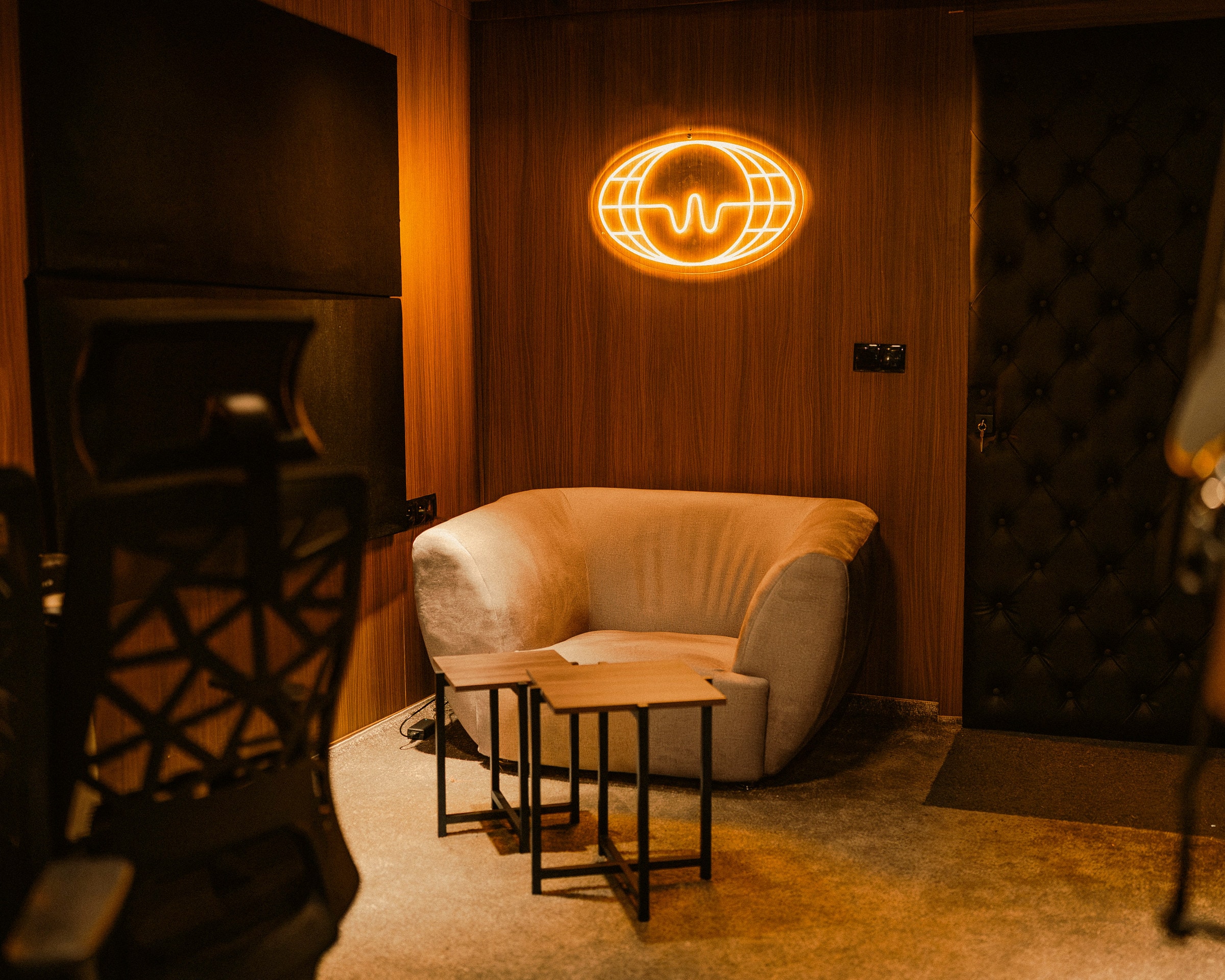 Coin lounge avec fauteuil et logo Wardd en néon